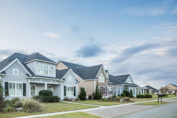 A street view of a new construction neighborhood with larger lan